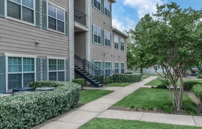 a house with bushes in front of a brick building
