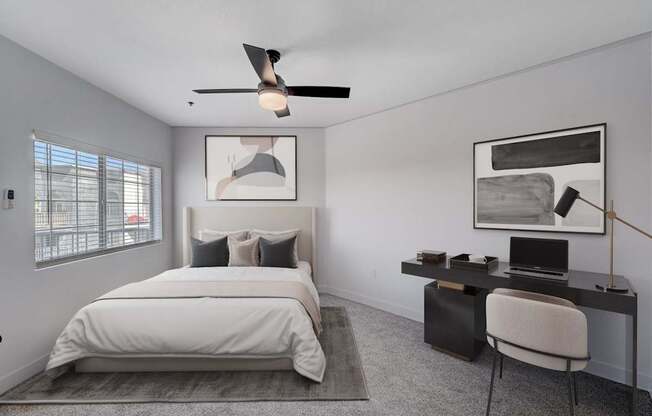 A bedroom with a bed, desk, and chair.