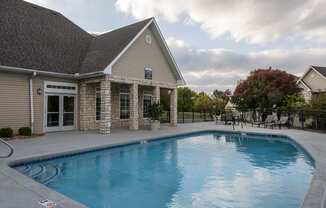 Pool with chairs and clubhouse in view