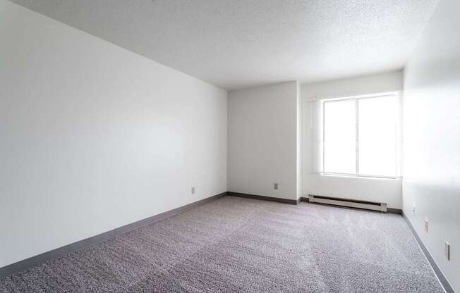 A room with a carpeted floor and a window. at Bristol Ridge, Urbandale, 50322