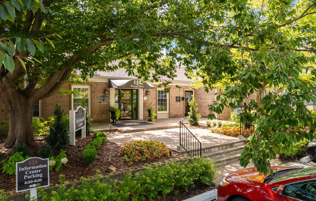 a house with a driveway and a tree in front of it