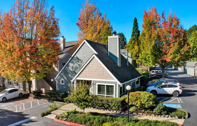 a small house in a parking lot with cars in front of it