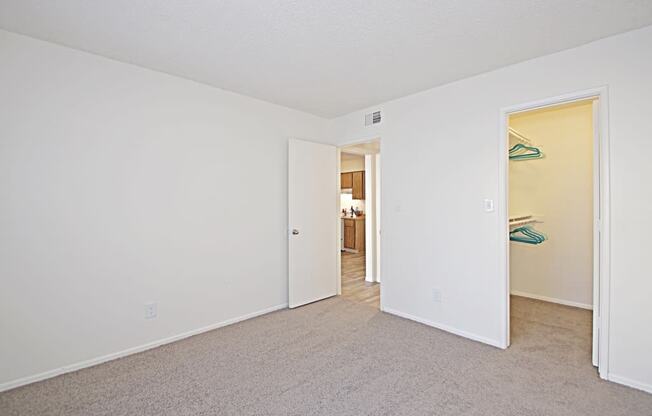 a bedroom with white walls and carpet