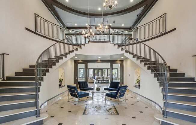 A large foyer with a staircase and a chandelier.
