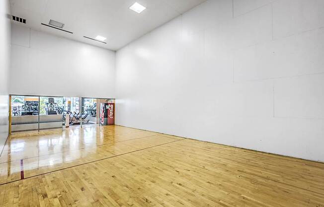 A large empty room with wooden floors and white walls.