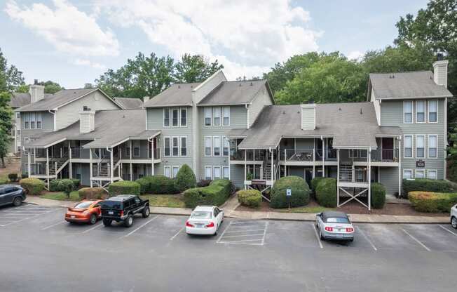 the apartment complex with cars parked in a parking lot