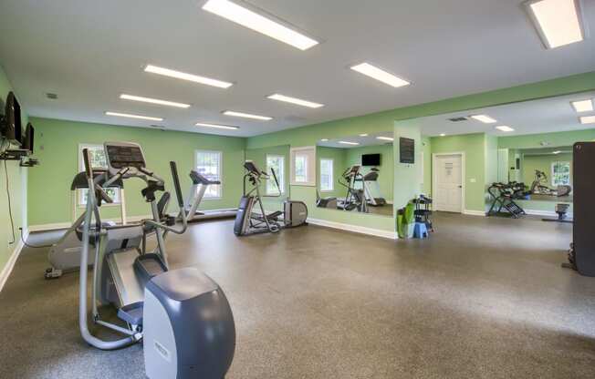 a large fitness room with treadmills and other exercise equipment