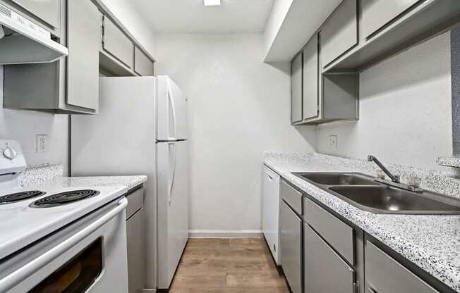 A kitchen with white appliances and a granite countertop.