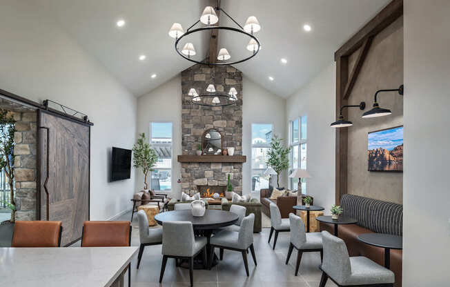 A modern dining room with a stone fireplace and a large table set for a meal.