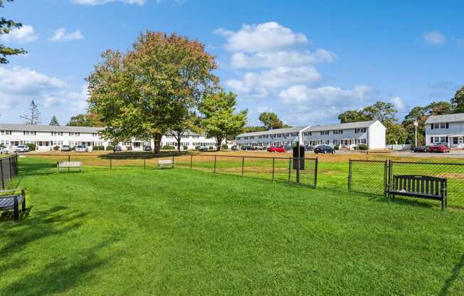 a dog park with benches and a fence in front of a building at Fox Hill Commons, Connecticut