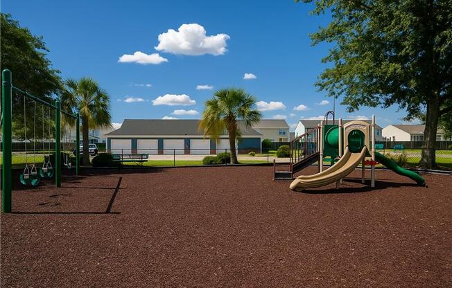 A playground with a green slide and a brown ground.