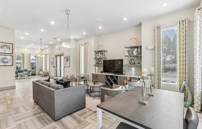 A well-lit, spacious living room with a grey sofa and a grey coffee table.