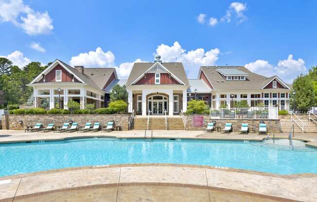 a large swimming pool with a house in the background