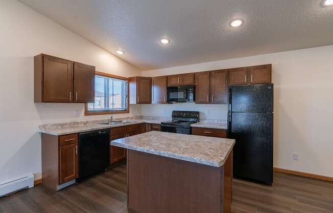 a kitchen with black appliances and white countertops. Fargo, ND Westwood Apartments