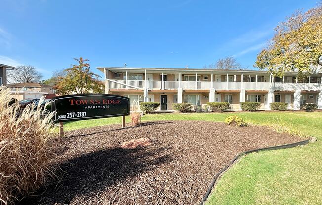 A sign for Down's Ridge Apartments is in front of a building.