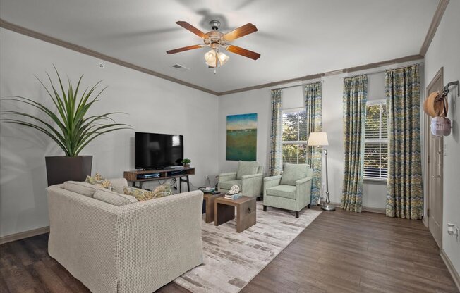 a living room with a ceiling fan and couches