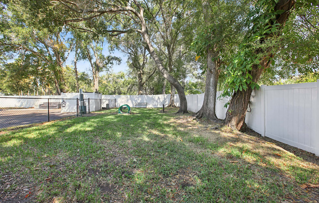 A white fence encloses a green park area.