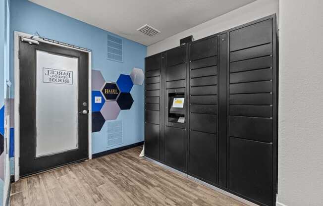 a hallway with black doors and a blue wall with a door to the elevator
