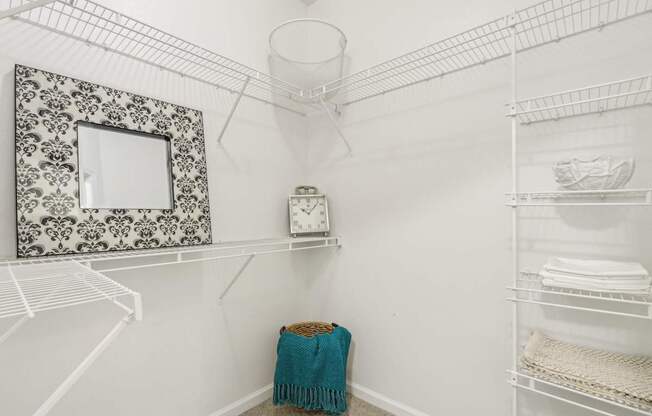 A white pantry with a mirror and a towel on the floor.