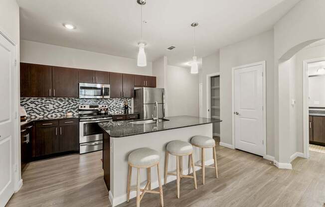 A kitchen with a bar and stools.