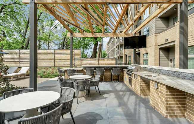A patio with tables and chairs under a wooden roof.