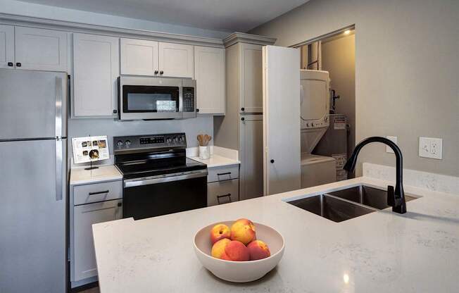 A kitchen with a bowl of fruit on the counter.