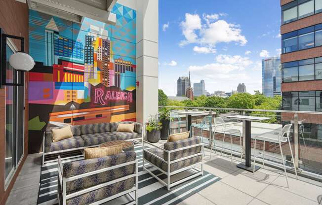 a terrace with couches and a table and a mural on the wall