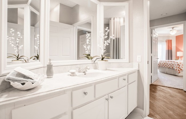 a white bathroom with a large mirror and a sink