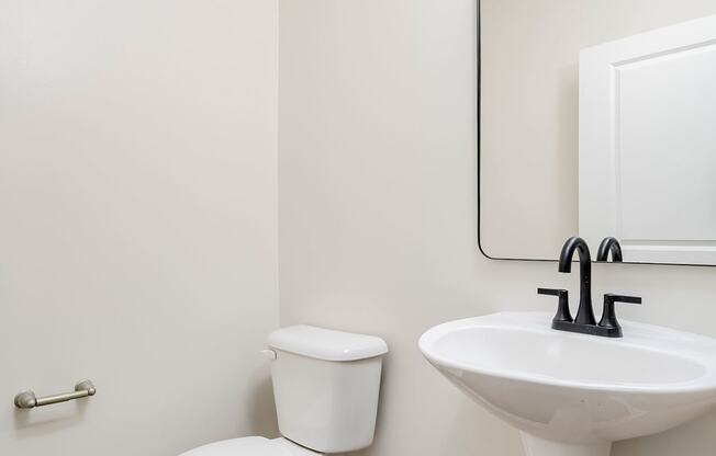 a bathroom with a toilet sink and mirror