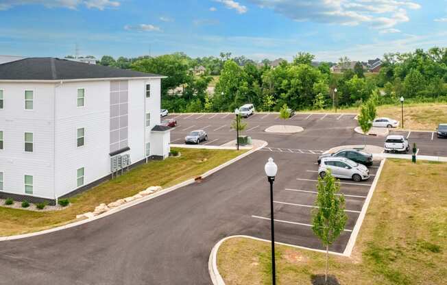 a white building with cars parked in a parking lot