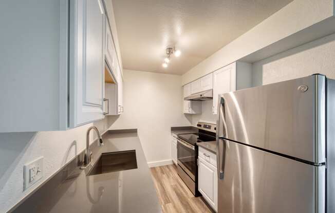 a kitchen with stainless steel appliances and white cabinets
