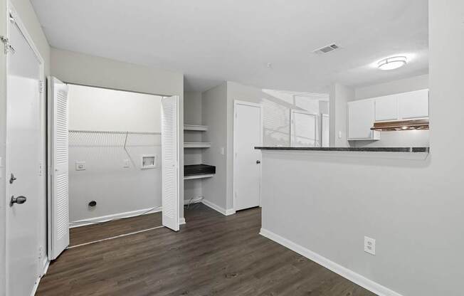 A white room with a wooden floor and a white door.