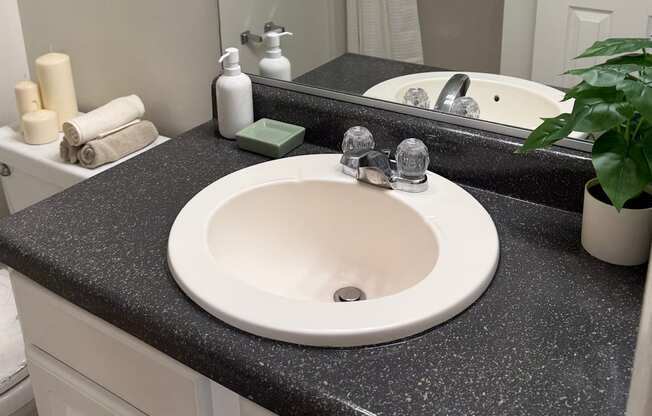 A bathroom sink with a black granite countertop.