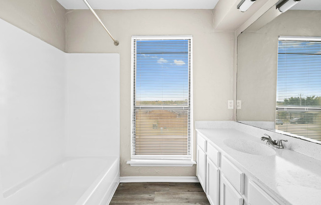 a bathroom with a tub and a sink and a window at Diamond Ridge Townhomes, Oklahoma ,73114
