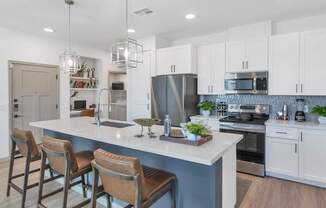 A modern kitchen with a bar area and stools.