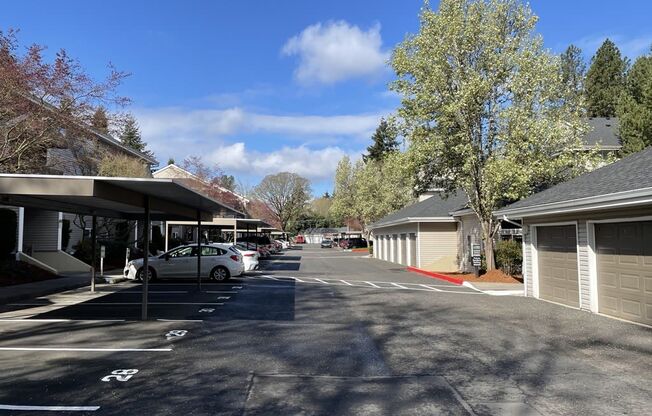 a parking lot in front of a house with a blue sky in the background