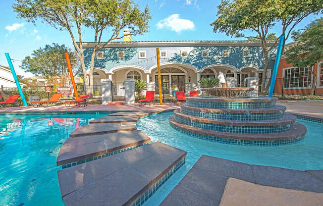 A pool with a water slide and a building in the background at Reserve at Canyon Creek, San Antonio,TX,78230
