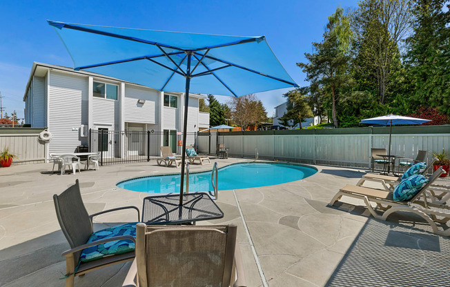 Cool Swimming Pool with Lounge Chairs and Shaded Bistro Table Set at Campo Basso Apartment Homes, Washington, 98087