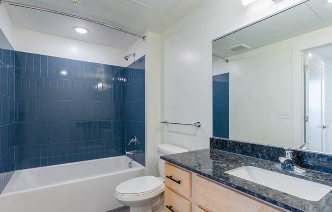 A bathroom with a white tub, sink, and toilet.