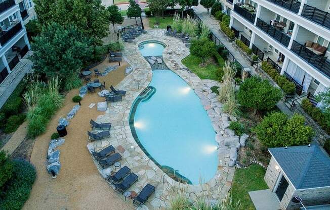 an overhead view of a swimming pool in front of an apartment building
