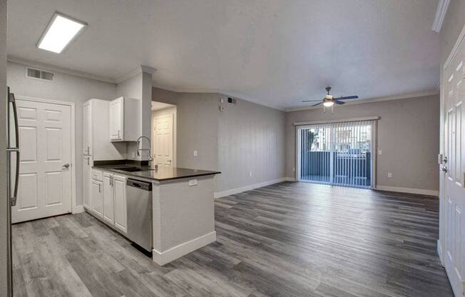 A spacious kitchen with a refrigerator, sink, and cabinets.