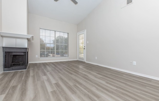 a living room with a fireplace and a large window