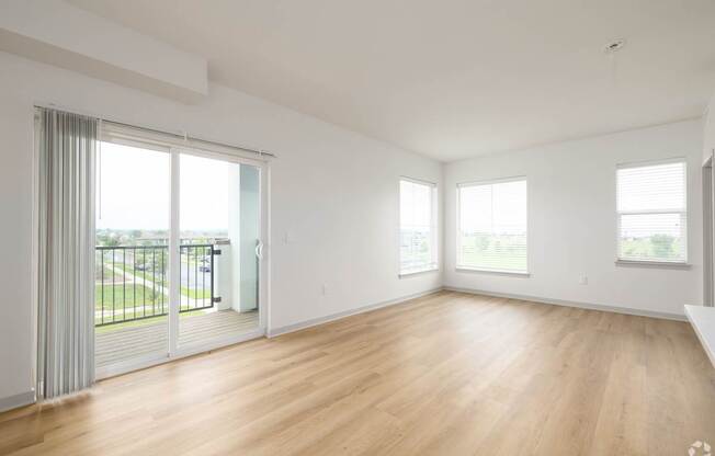 A large, empty room with wooden floors and white walls.