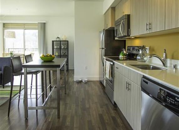 a kitchen with stainless steel appliances and a table