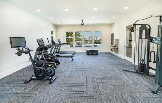 A bright, well-equipped fitness center at Amavi Kissimmee offers space to recharge, with views of the pool and everything you need for a balanced routine.