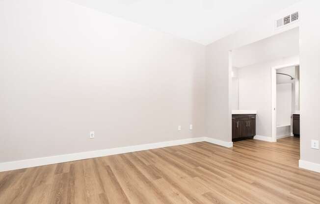 an empty living room with white walls and wood flooring