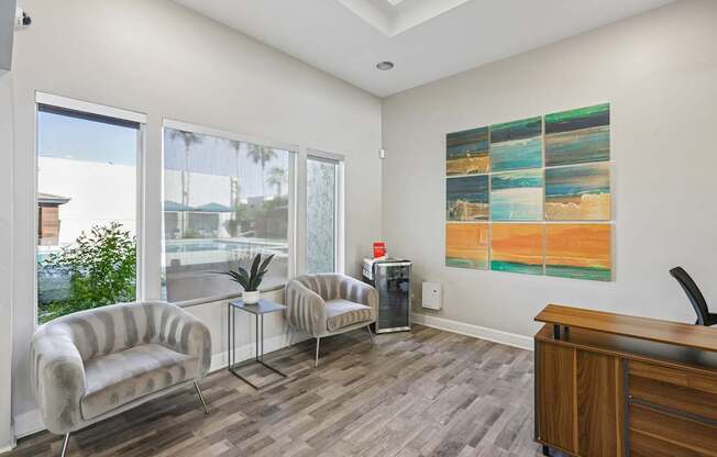 A waiting room with a wooden desk and a large painting on the wall.