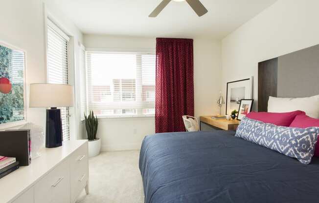 bedroom with large window and bed and dresser