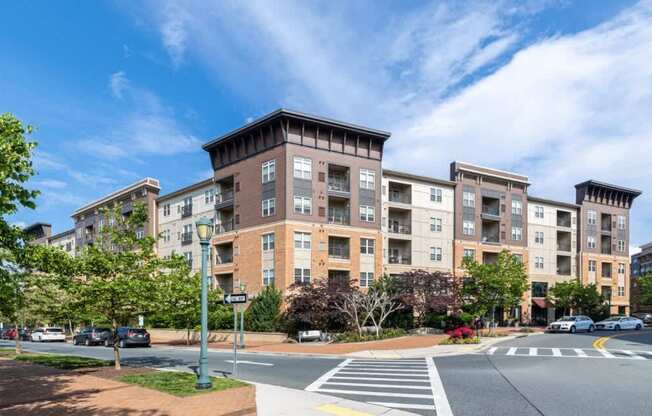 A large apartment building with a crosswalk in front of it.