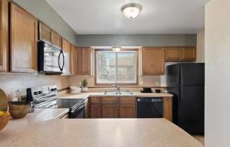 a kitchen with black appliances and wooden cabinets